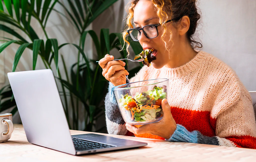 Person feeling energized at a bright workspace with healthy food nearby
